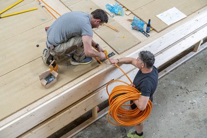 Hier werden bereits die Rohre angeschlossen und verlegt, die die einzelnen Platten miteinander zum Heizsystem verbinden. 
